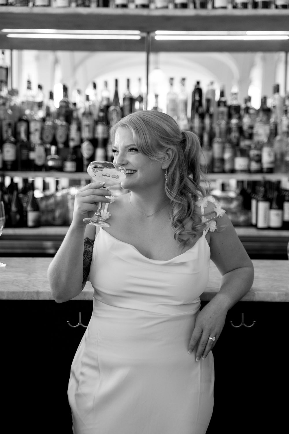 Elegant bar scene with champagne glass and illuminated bottle display.
