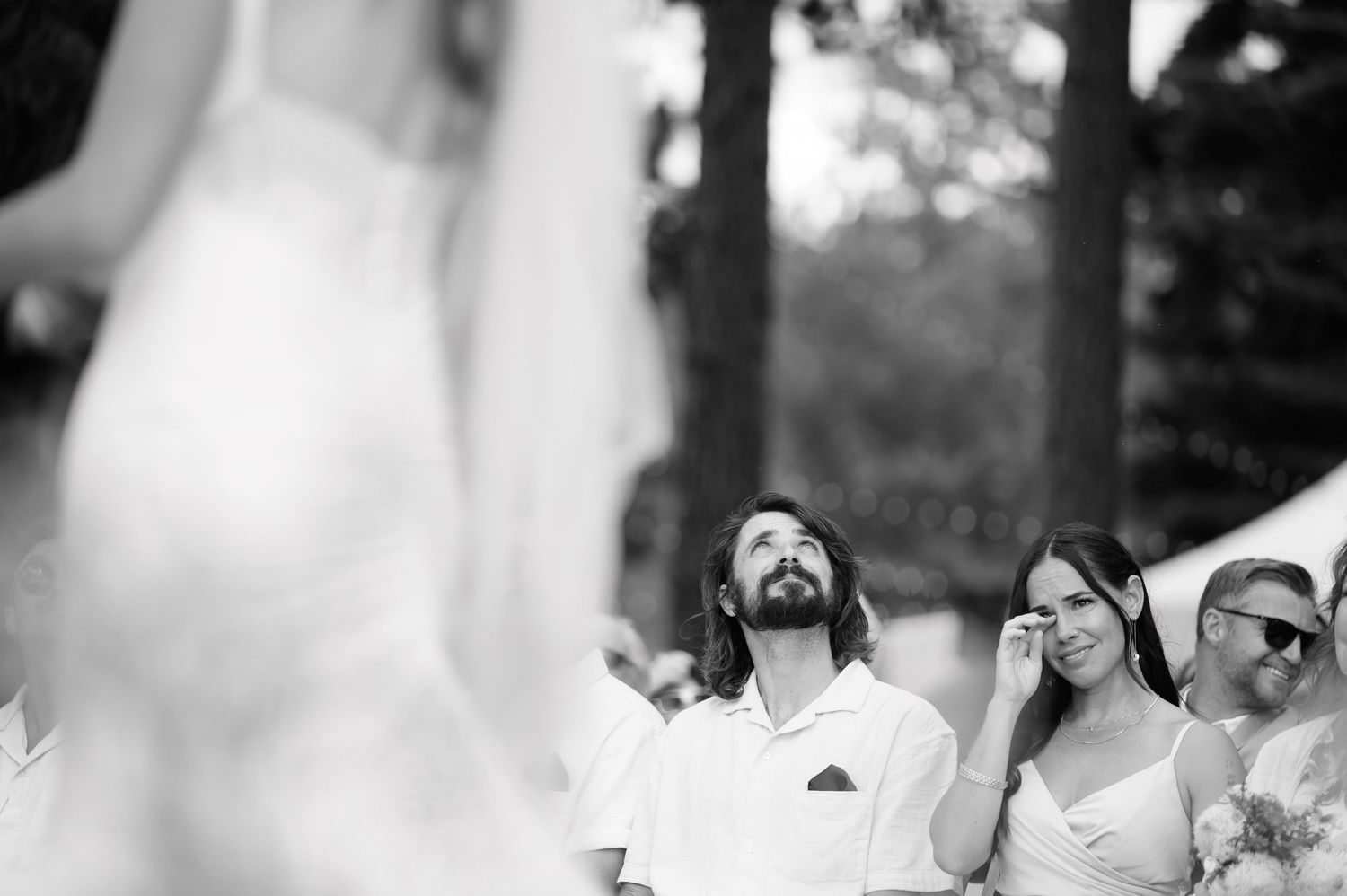 Two people dance together during a joyful outdoor wedding reception surrounded by other guests.