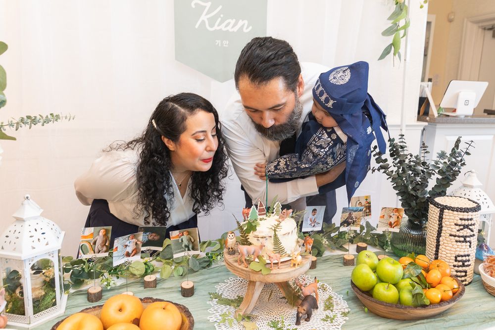 A family gathers around a beautifully decorated table with fresh fruits and treats during a celebration.