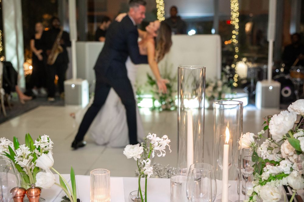 Jeff dips and kisses Emma on the dance floor as destination wedding photographers in Palm Beach capture the moment