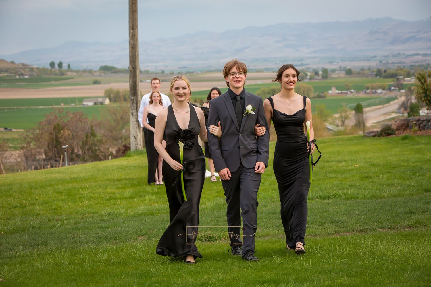 one groomsman with 2 bridesmaids in formal black attire