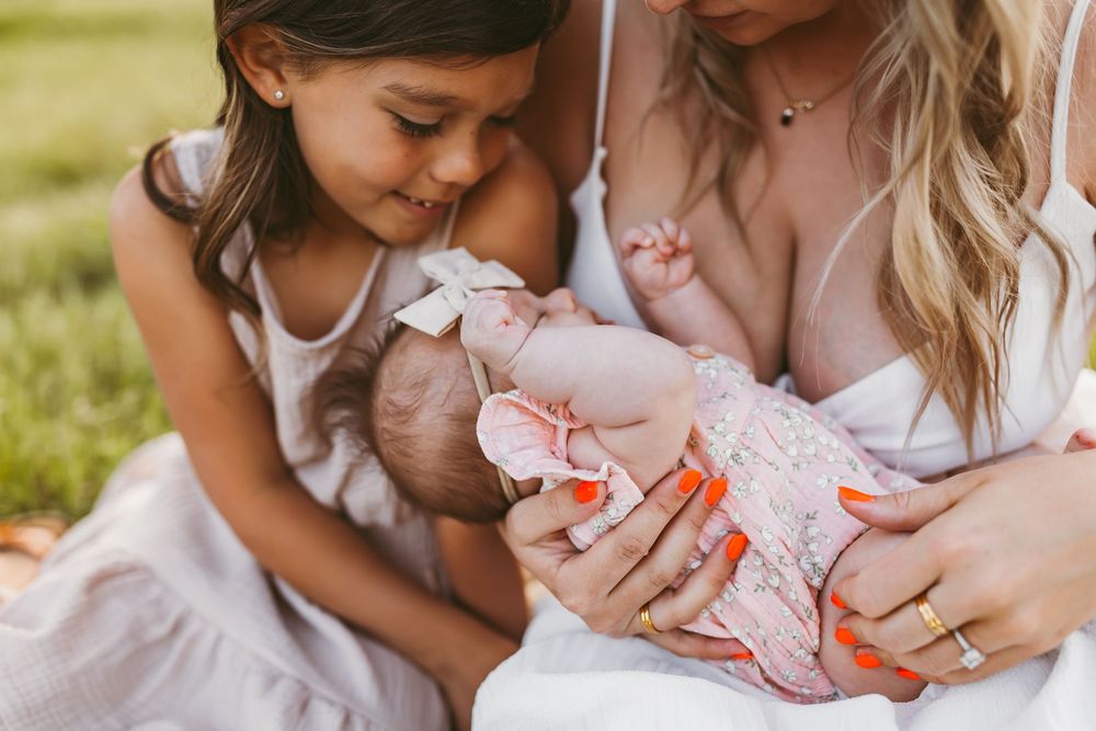 Intimate family bonding moments captured outdoors with children and baby.
