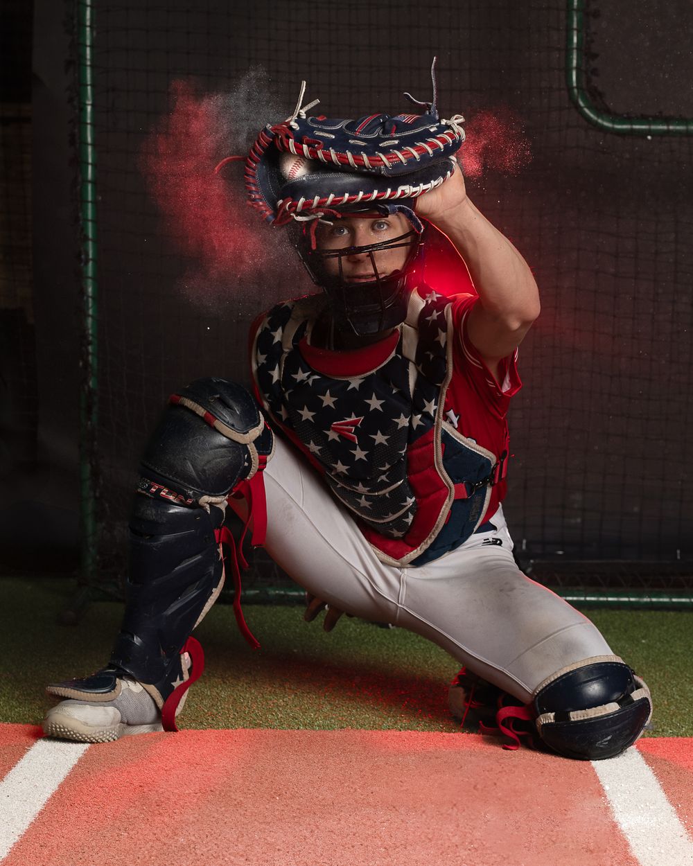 dramatic moody sportrait of a club baseball player in a crouched position with dramatic lighting