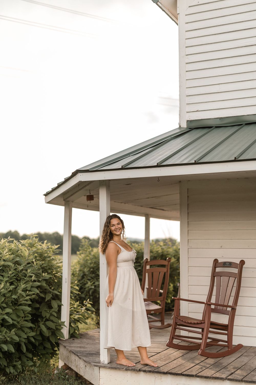 A series of four photos showing someone in a white dress walking and posing on a rustic wooden front porch with rocking chairs.