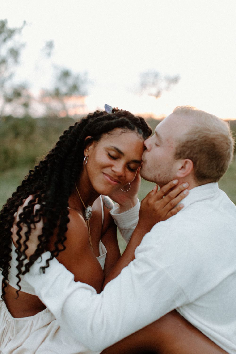 A tender moment captured between a couple during sunset outdoors.
