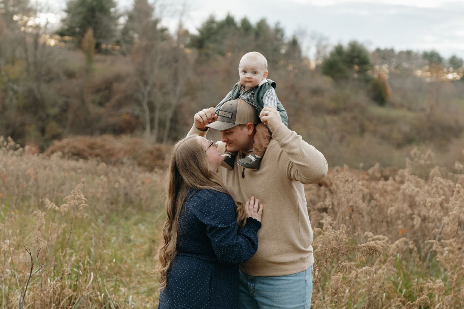 Intimate family moment captured against a backdrop of rolling hills and autumn trees.