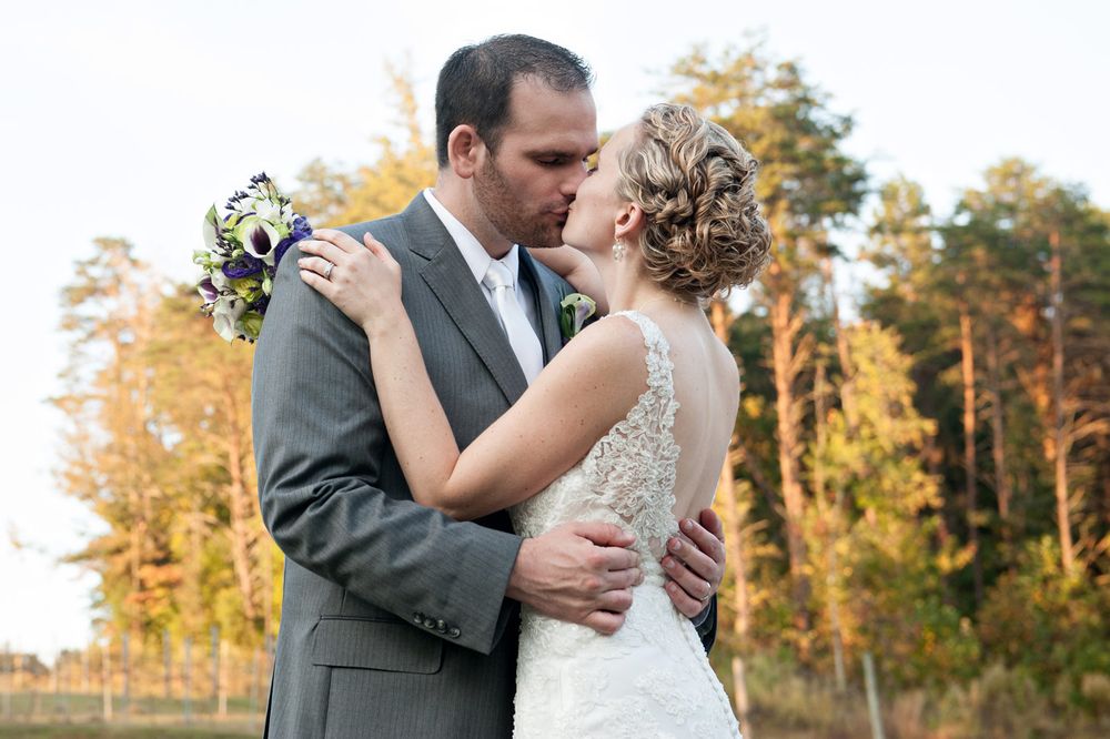 Wedding couple shares intimate embraces during golden hour sunset photoshoot in an outdoor forest setting.