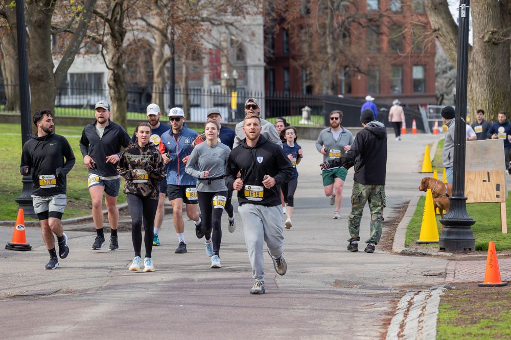 Group of runners following curved path during outdoor racing event.
