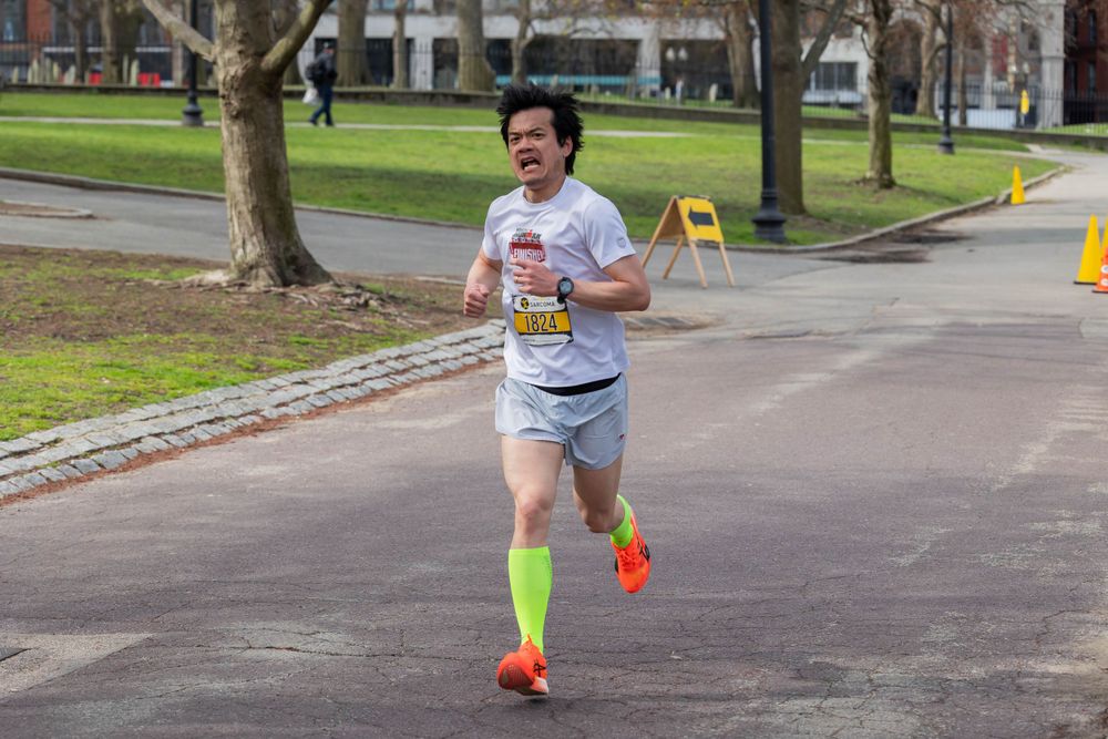 Runner in bright colored socks participating in outdoor race event.