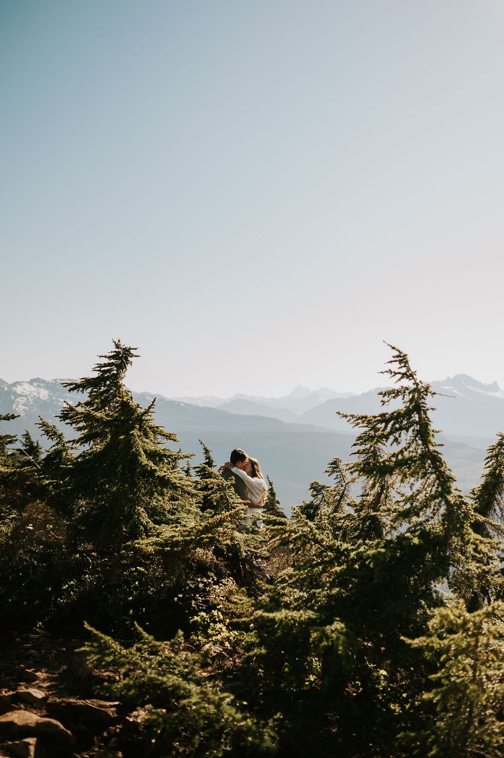 Romantic couple kissing at Mount Washington, framed by dramatic mountain scenery by Photographer Soulfull Photographs