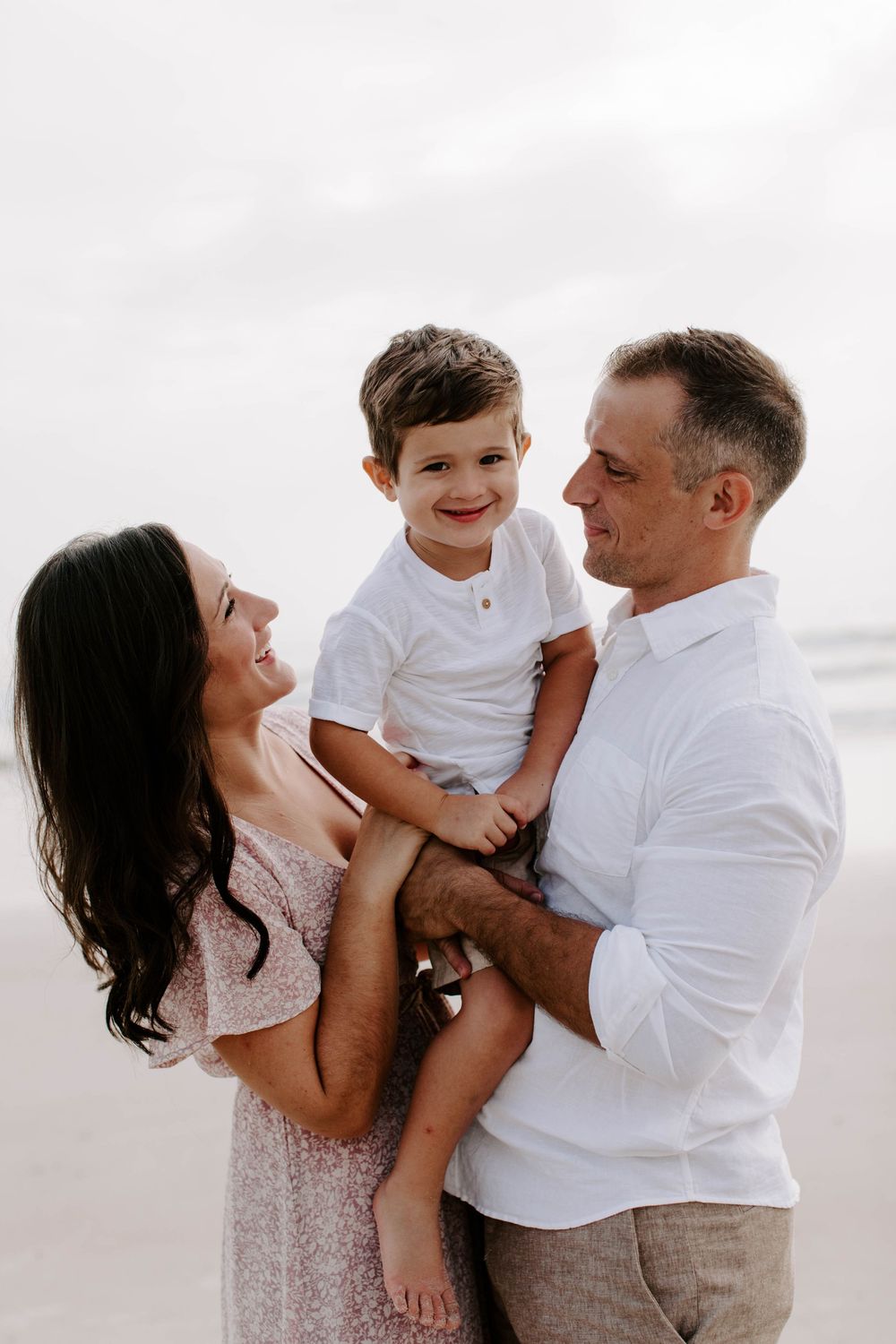 Candid family moment captured in a series of joyful interactions on the beach.