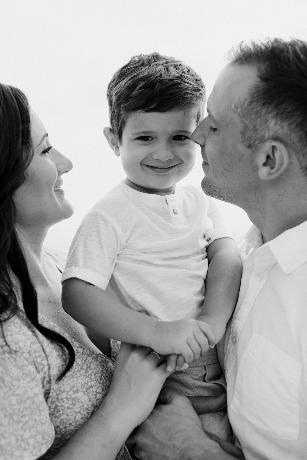 Series of intimate black and white family photos showing playful moments together.
