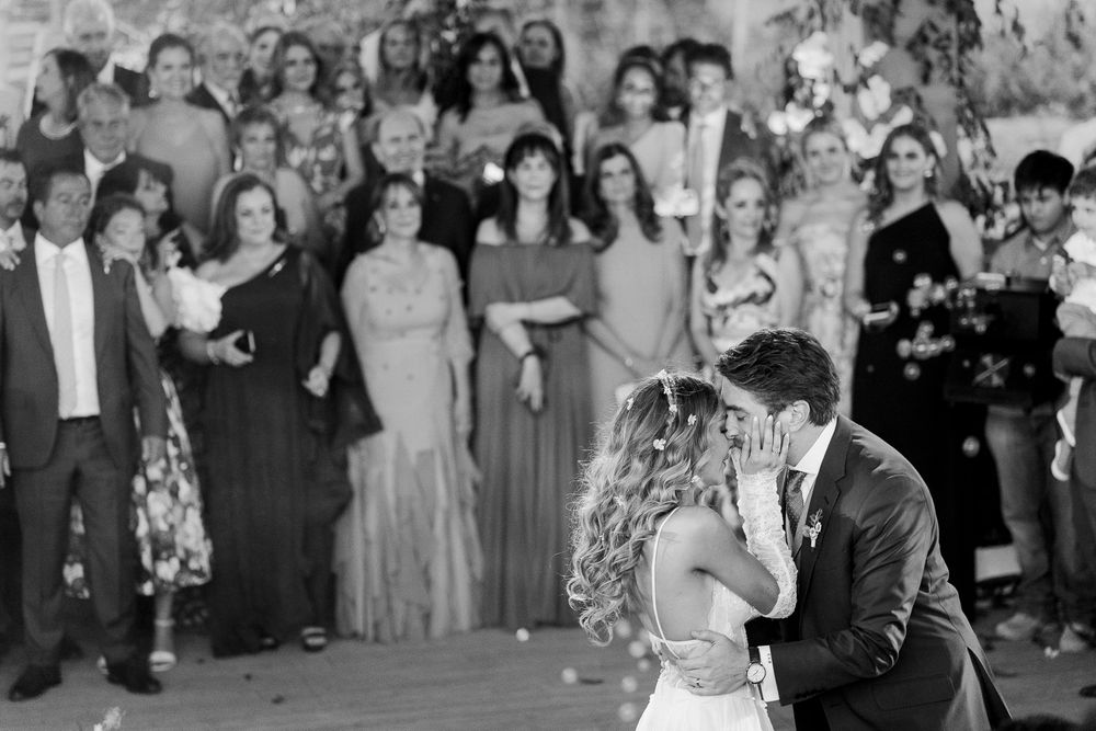 Wedding party dances together at reception as guests watch the celebration on the dance floor.
