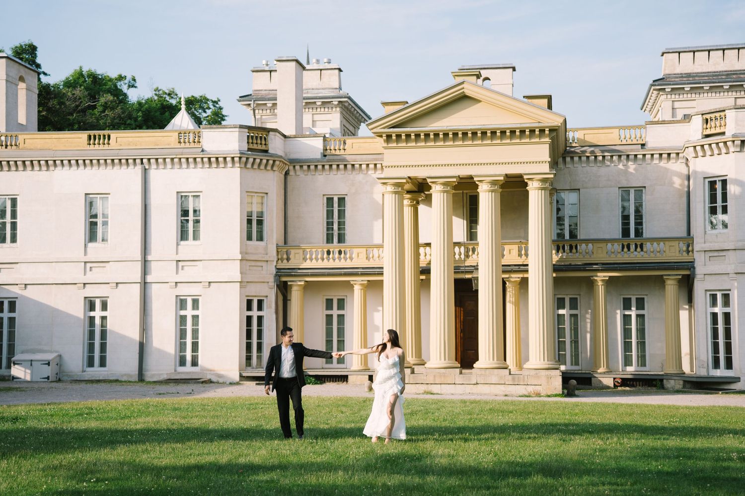 Couple poses in gothic archway with dramatic windows and natural light.