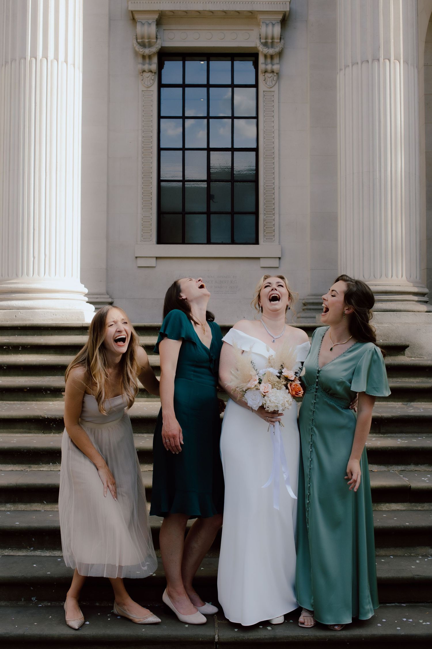 A fun series of candid wedding party photos showing bridesmaids laughing together on grand stone steps.