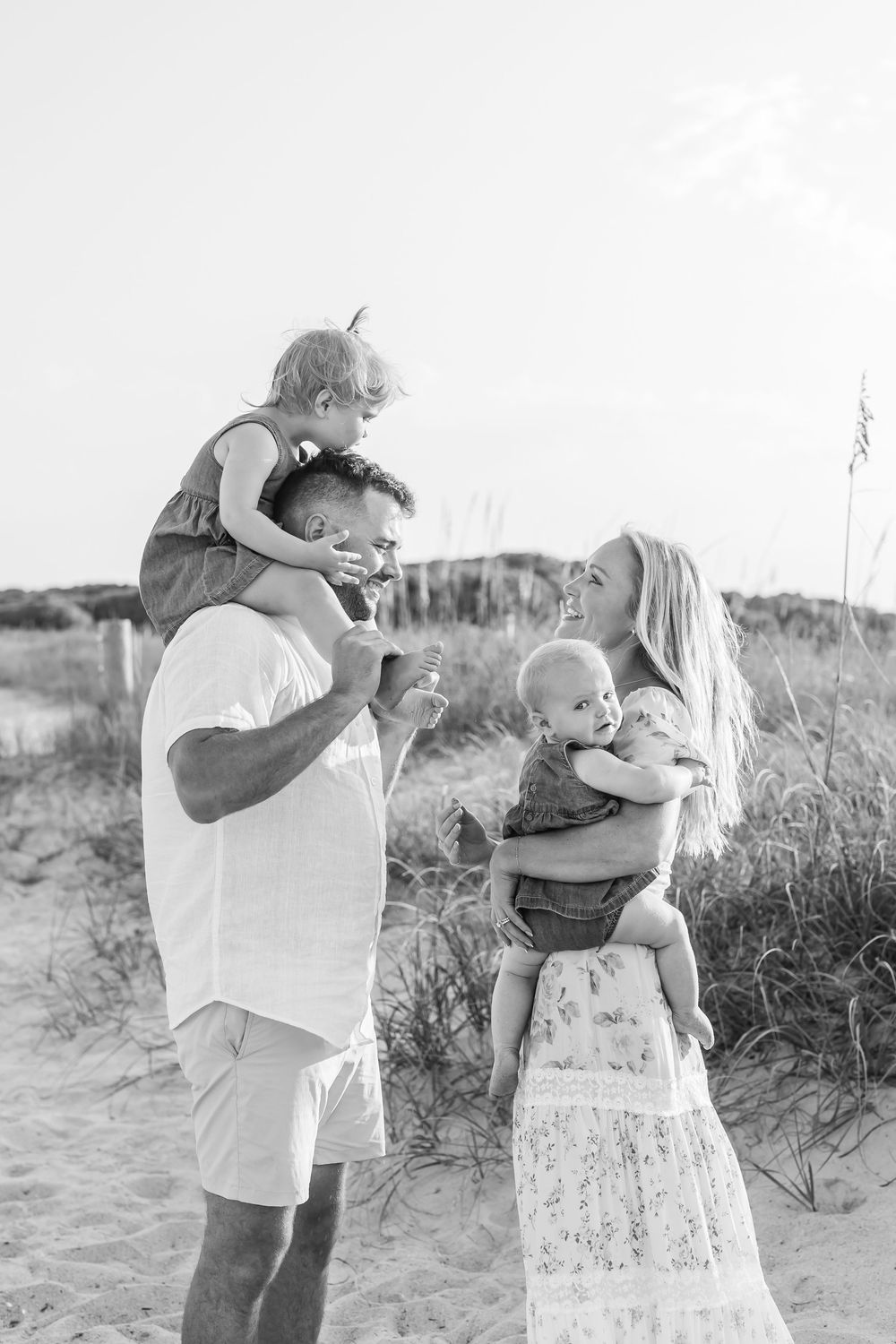 Family sharing tender moments together on beach during sunset photo session. Wilmington NC.