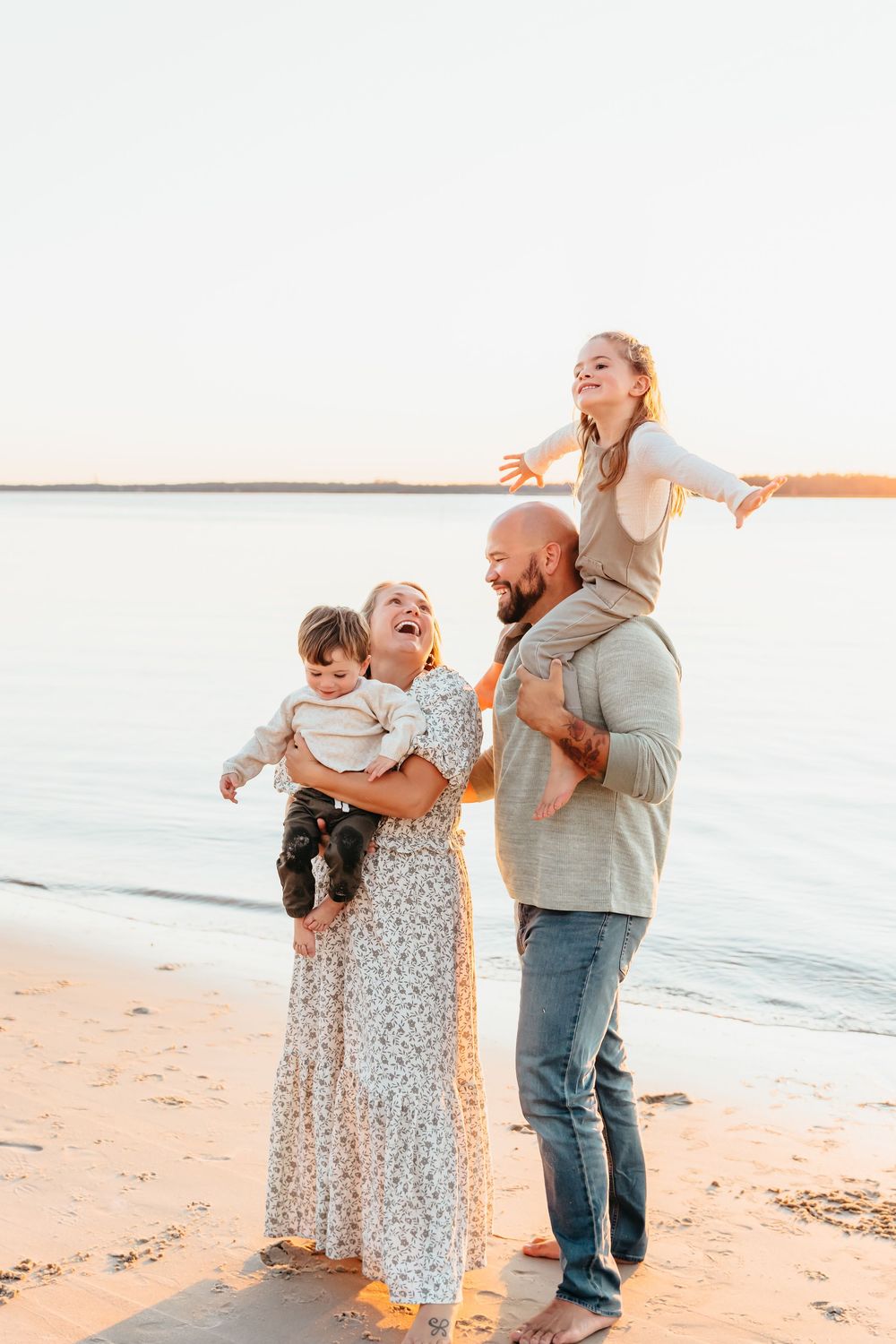 A joyful family moment captured at sunset on a beach, filled with laughter and embraces.