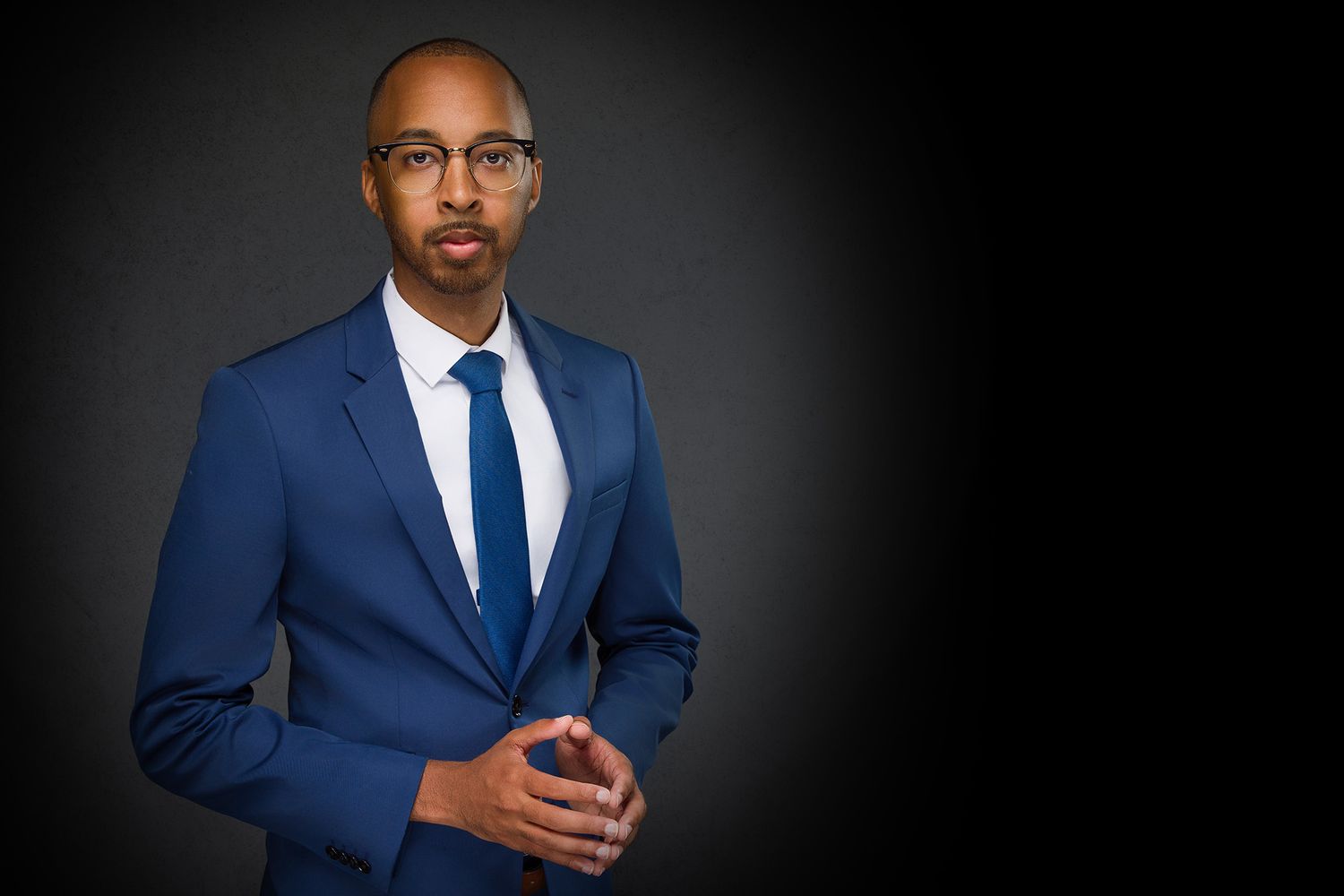 Professional portrait series showing person in blue suit and tie posing against dark background.
