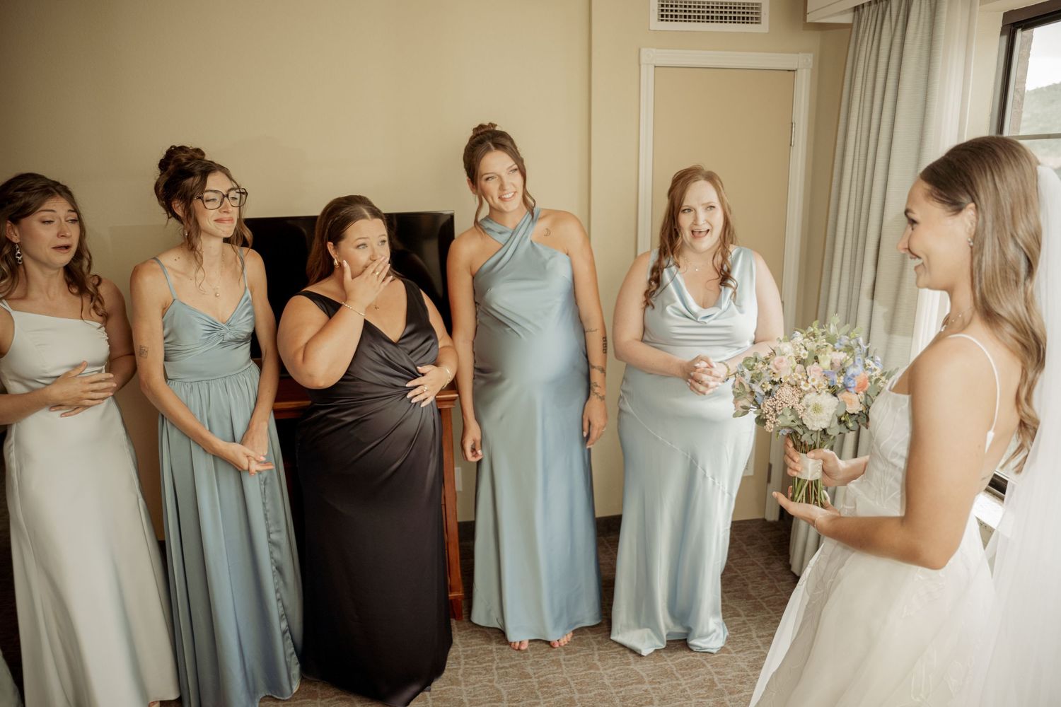 A romantic dip kiss between a couple in wedding attire while guests look on during their ceremony.