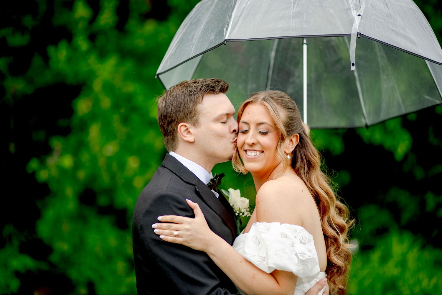 A romantic proposal scene set between rows of grapevines in a scenic vineyard with white flowers and a blanket.