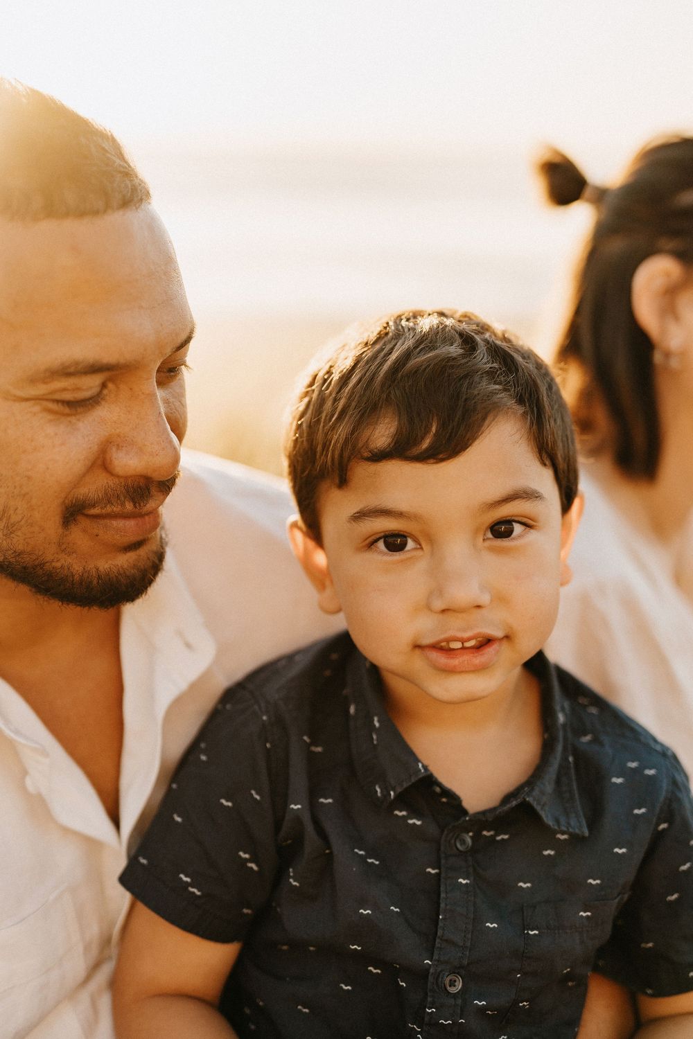A warm close-up portrait of a family sharing a tender moment together during golden hour.
