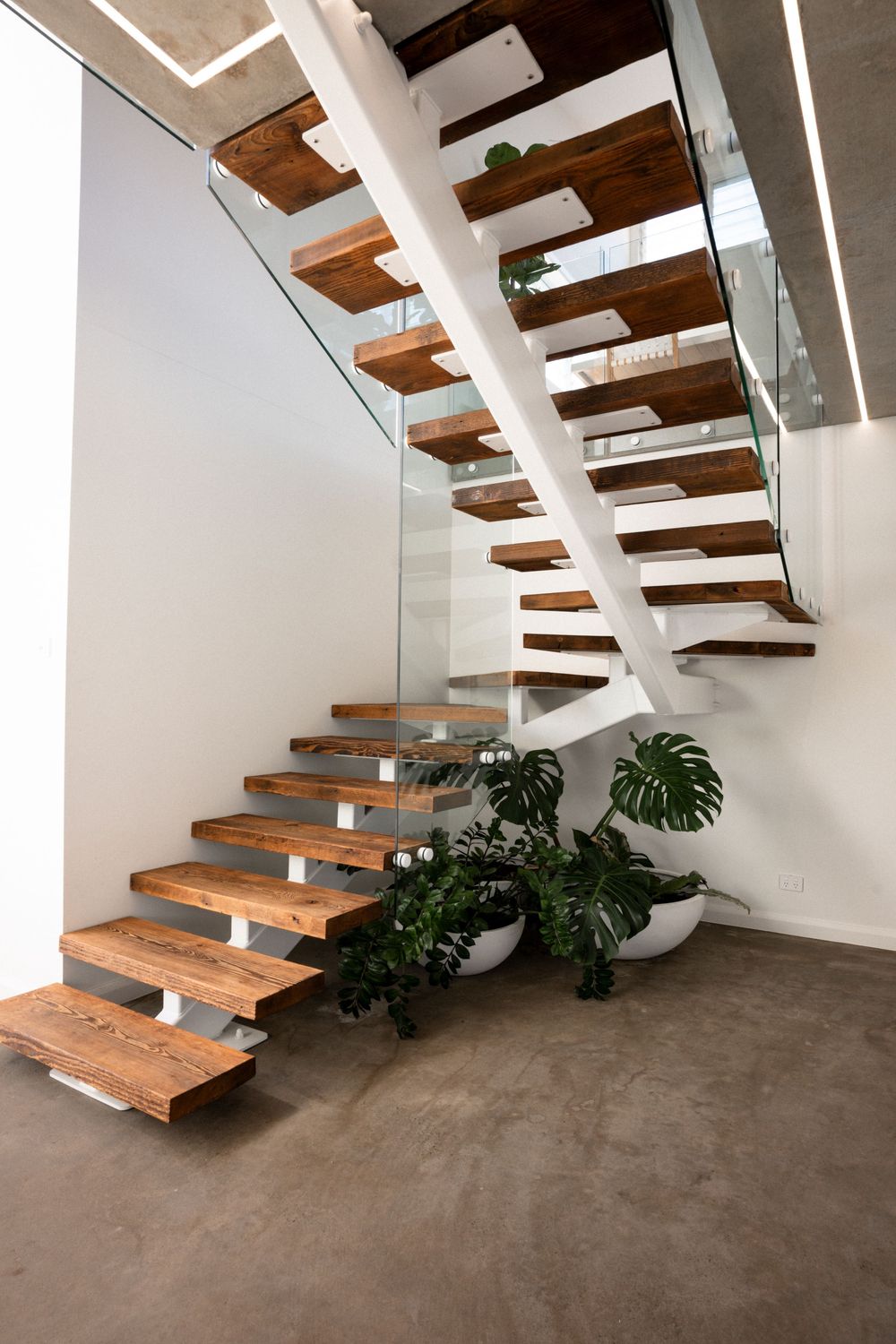 Modern floating staircase with wooden treads and white railings showcased from six different angles in a minimalist interior.