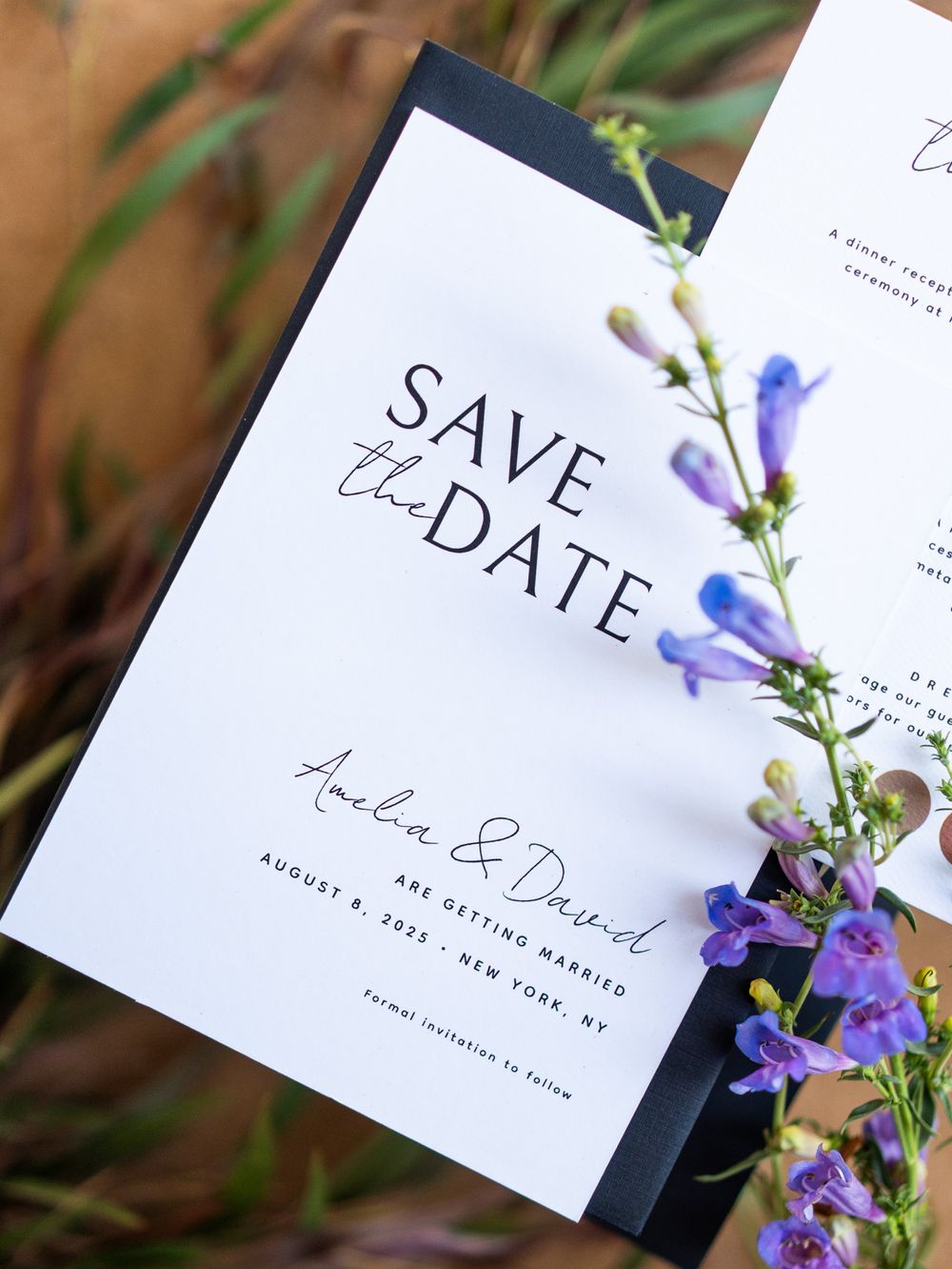 Minimalist wedding save the date cards with elegant calligraphy and purple wildflowers arranged in natural light.