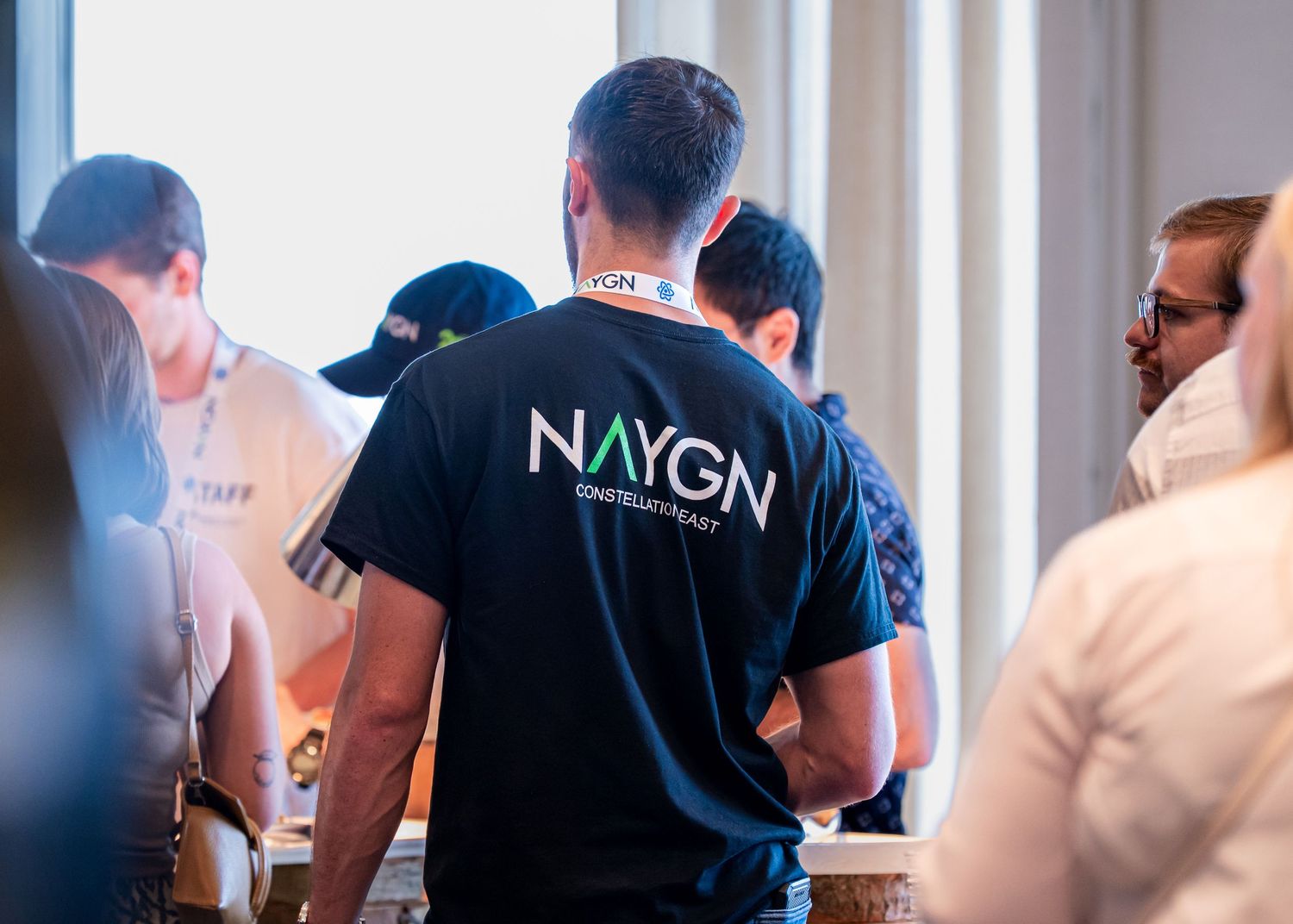 Person wearing a NYGN branded t-shirt at a networking event.