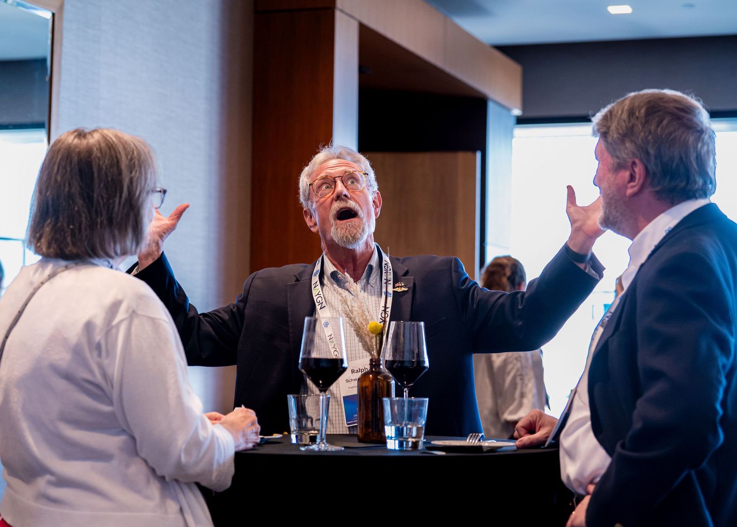 Animated conversation during a social gathering over drinks and refreshments.