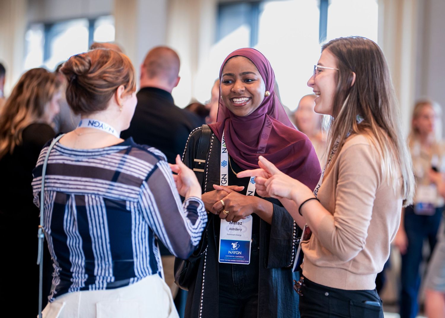 Group of diverse attendees engaged in lively conversation at a professional networking event.