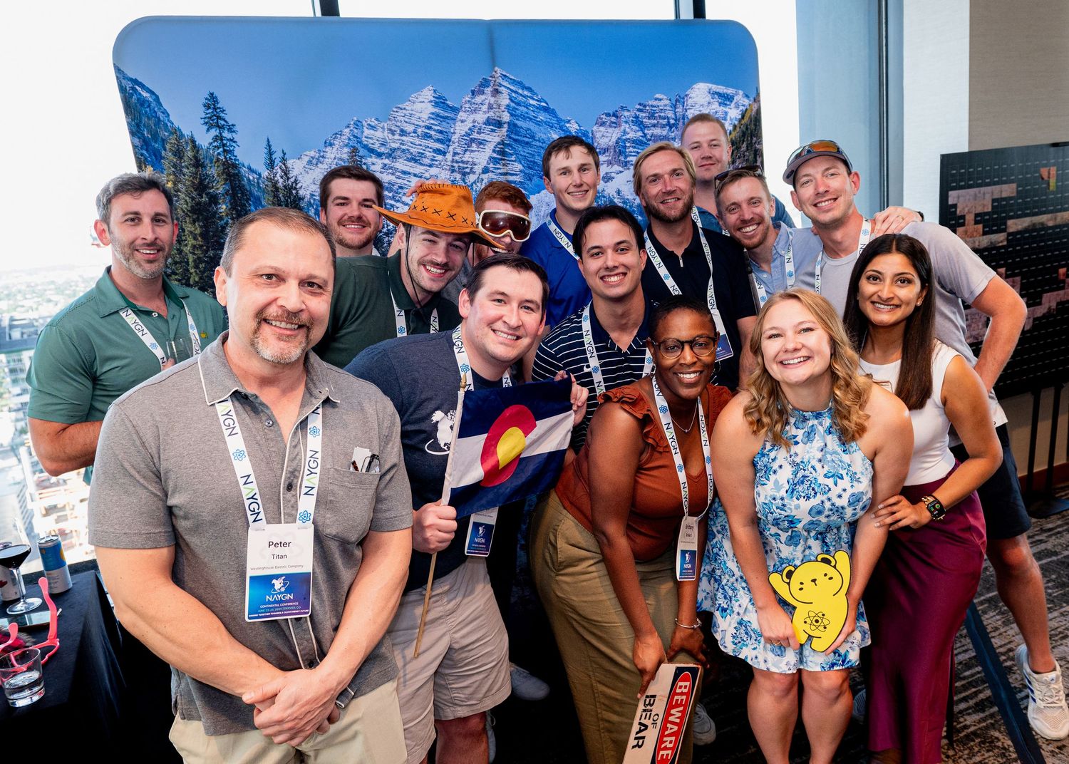 Group poses together at conference with mountain backdrop.
