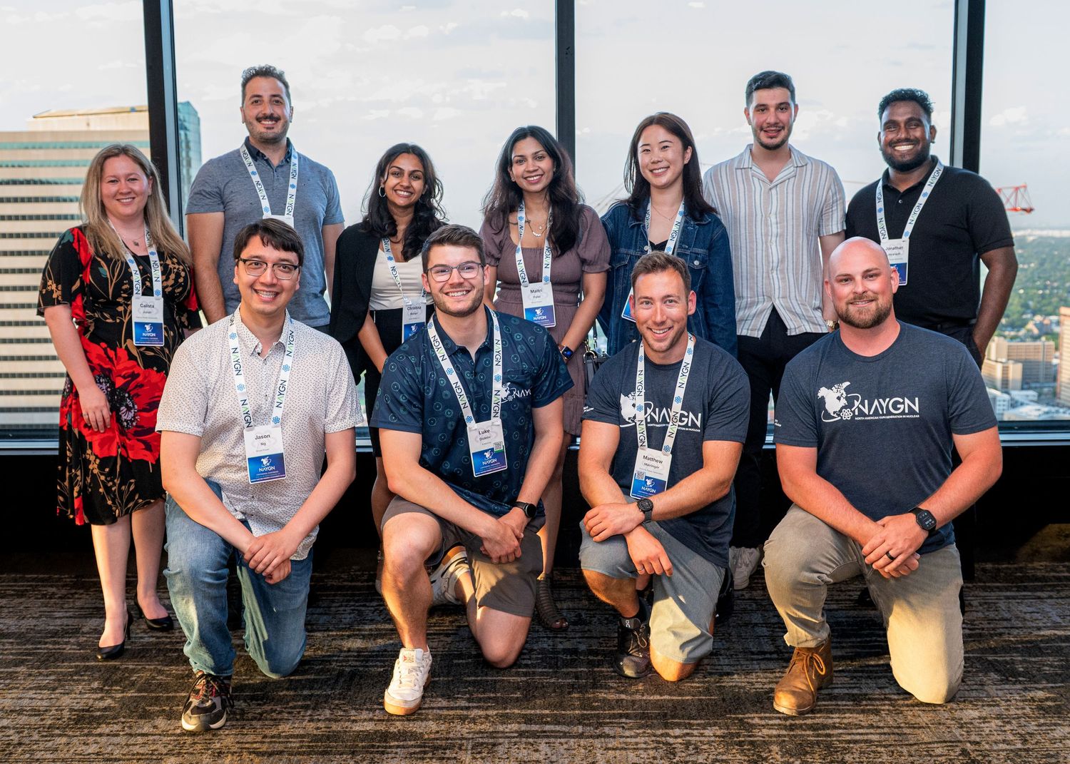Professional group photo of team members on outdoor deck.