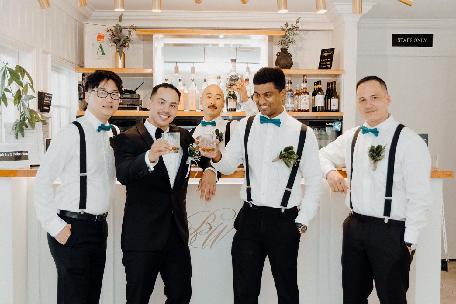 The groom and his groomsmen in black and white attire pose together captured by Apertured Media Auckland Wedding Photographer.