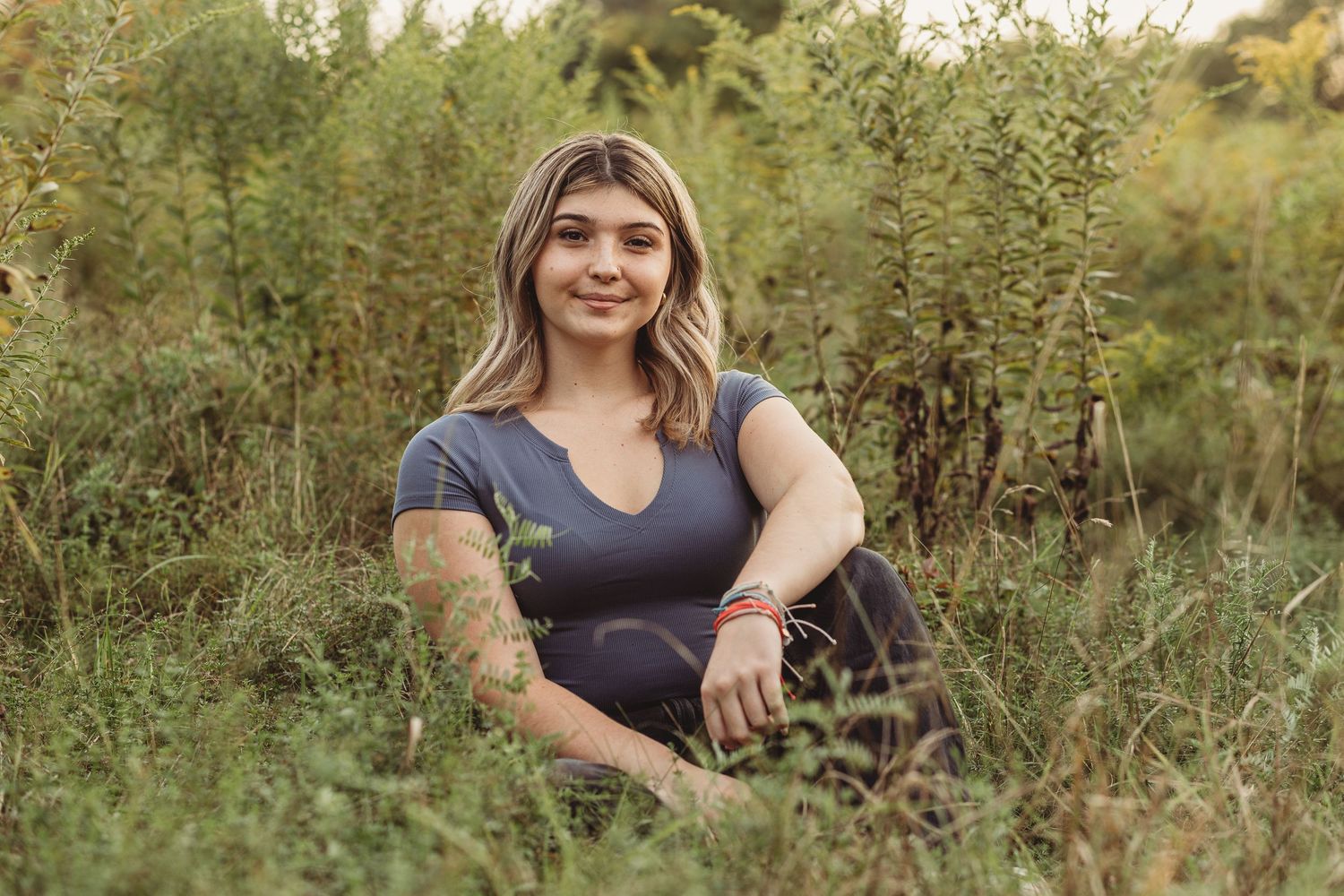 Professional senior photo of a girl sitting in the grass