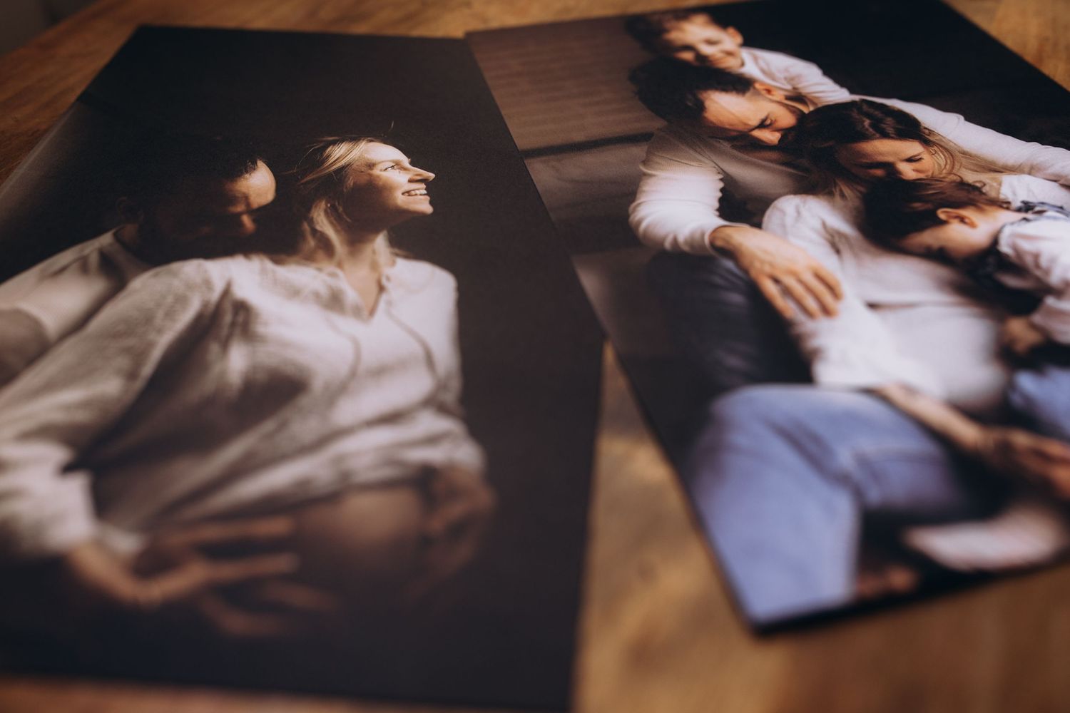 Old vintage photographs laid on brown wooden surface showing moody artistic portraits.