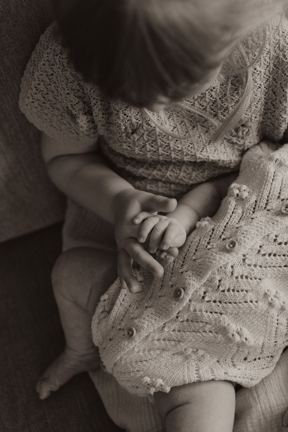 Baby's tiny feet rest on a delicate white crochet blanket in a series of black and white photographs.