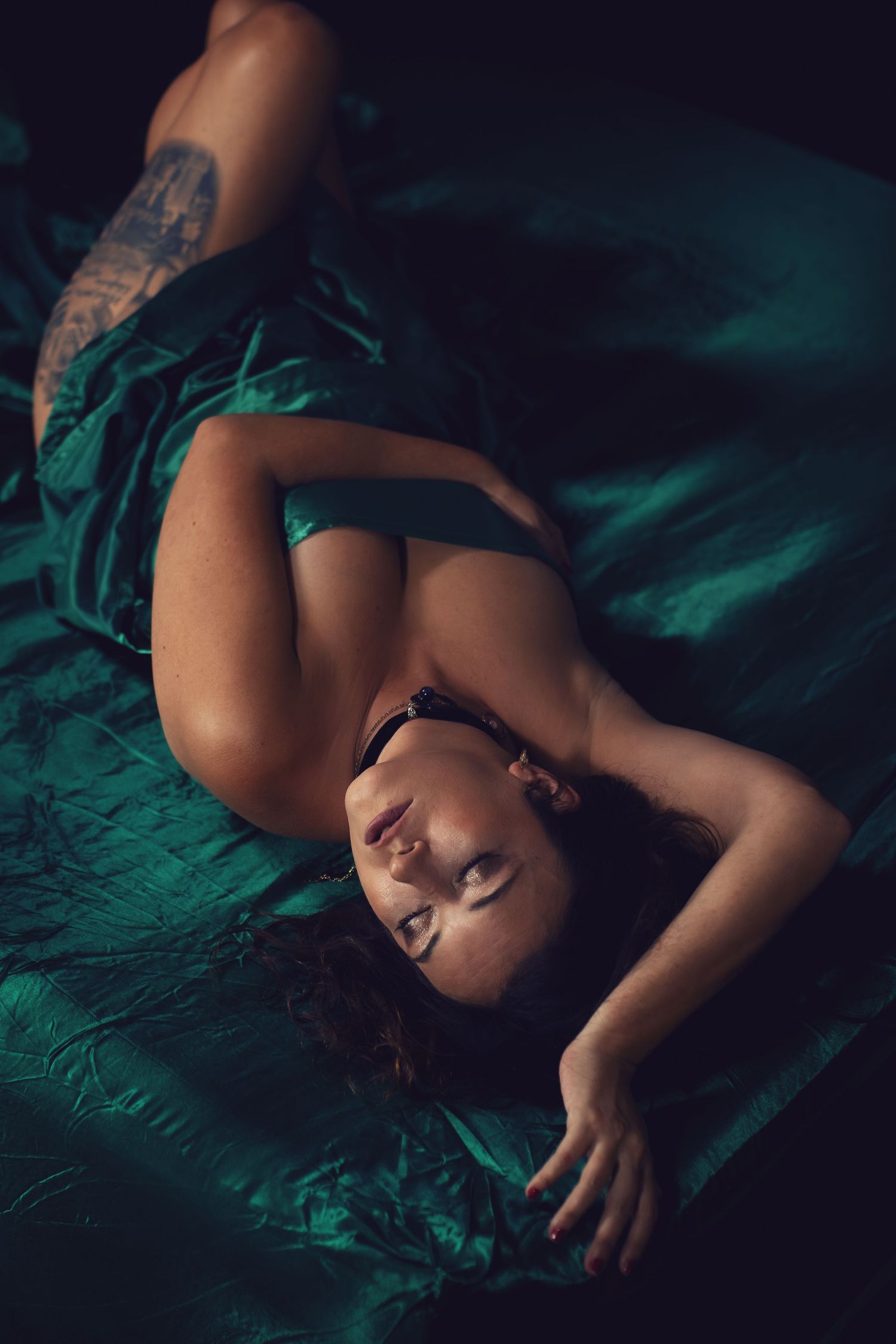Luxury boudoir photography Fort Worth session featuring confident woman on emerald bedding captured by top DFW boudoir photographer.