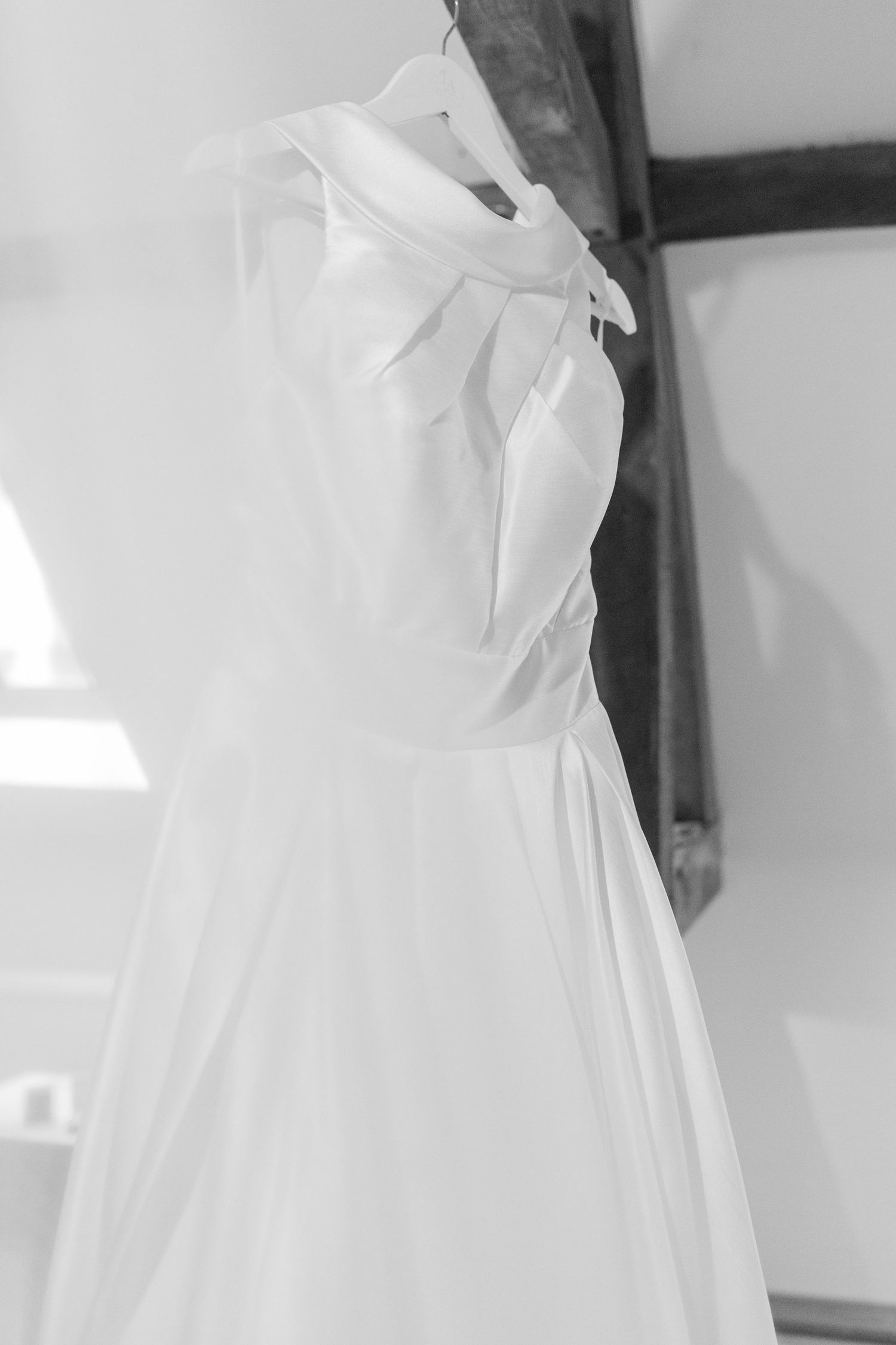 Elegant white wedding dress by Ronald Joyce with veil in the foreground hanging. Wedding at Deer Park Hall Hayley Elizabeth photography