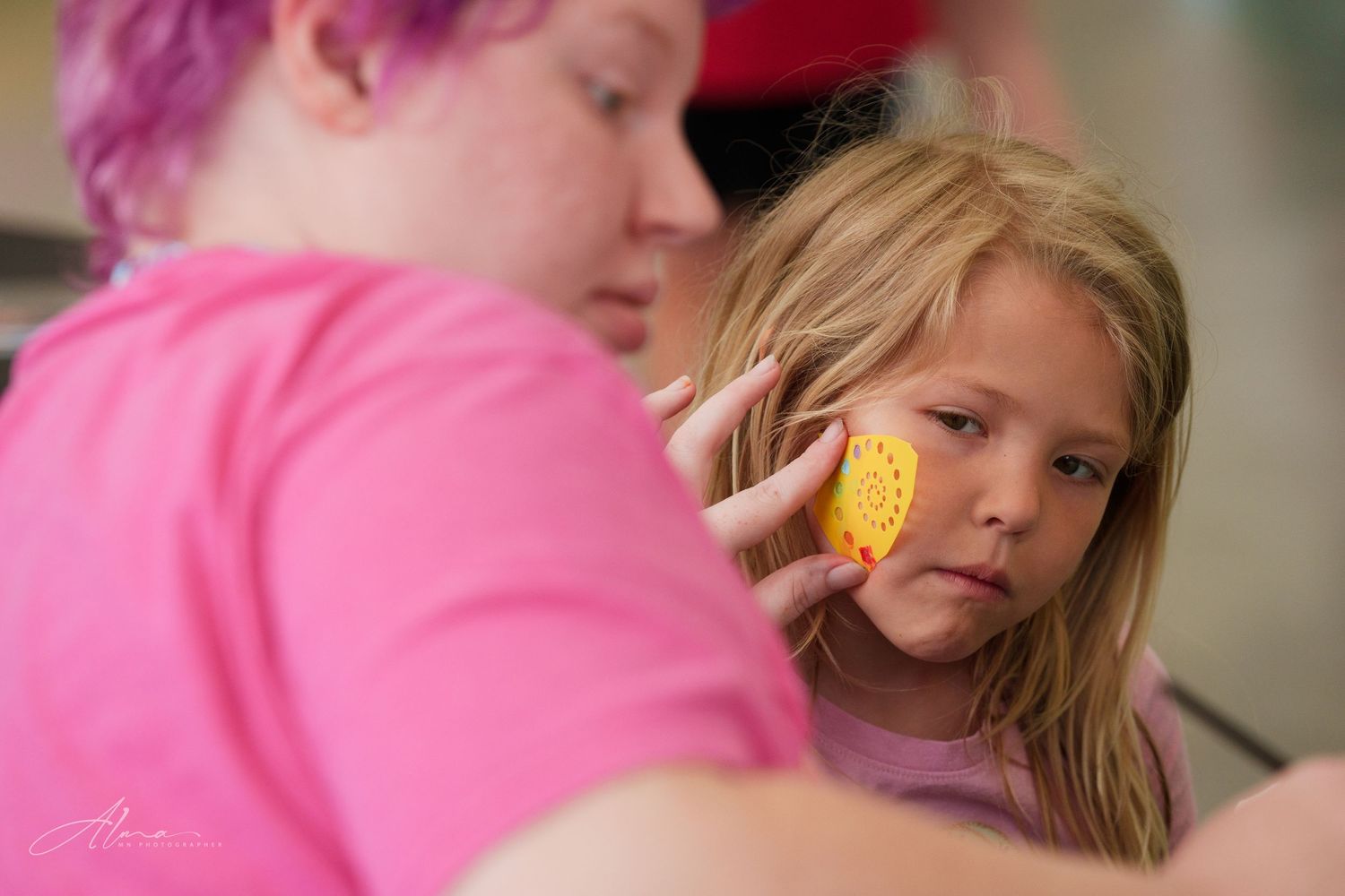 Close-up of face painting activity at community event with bright colors.