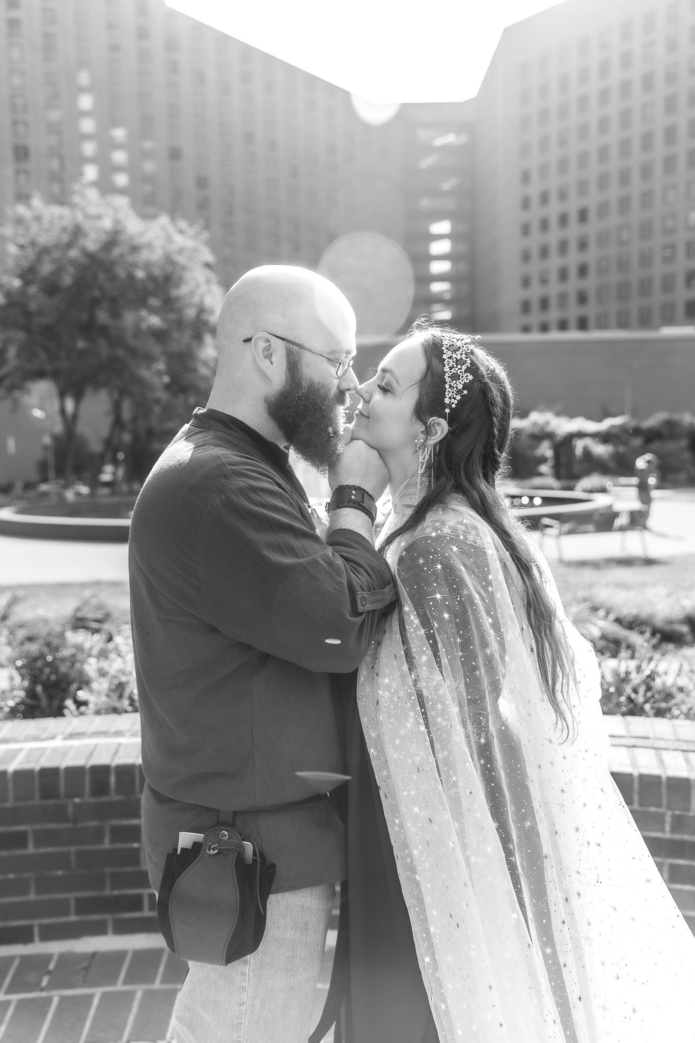 Romantic black and white wedding portrait in front of modern urban architecture.