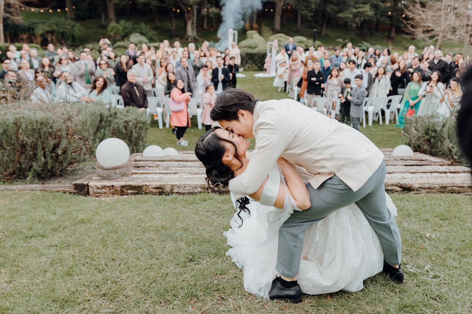 Groom's epic "Dip Kiss" to the bride after their wedding in Winsford Gardens. Captured by Apertured Media-Auckland Wedding Photographer