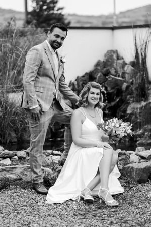 Wedding portrait of couple in garden setting with stone landscaping.