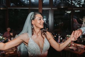 Bride in sparkly wedding dress dancing joyfully at the reception.
