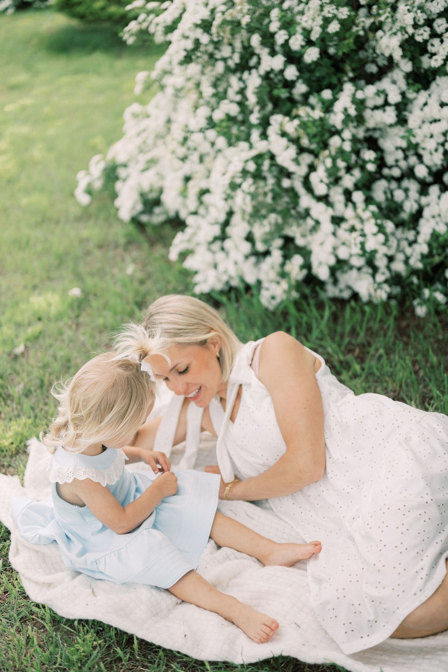 Sweet outdoor moment on blanket beneath flowering spring tree.