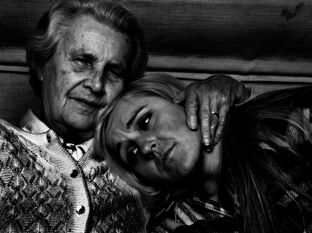 A tender black and white photograph shows two people sharing an intimate moment of comfort and connection.