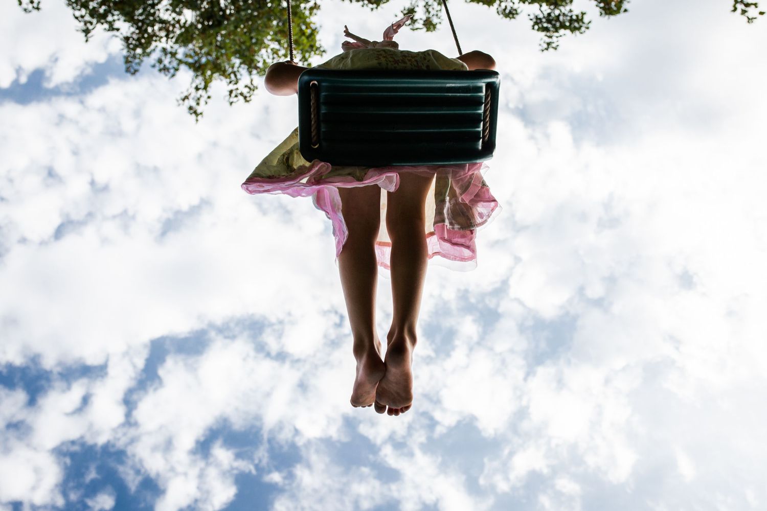 Child on a swing. Close up of feet.