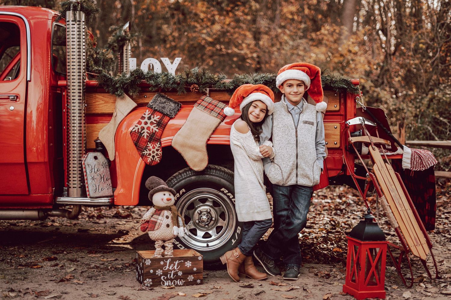kids standing in front of red truck full of christmas decoration during holiday red truck session