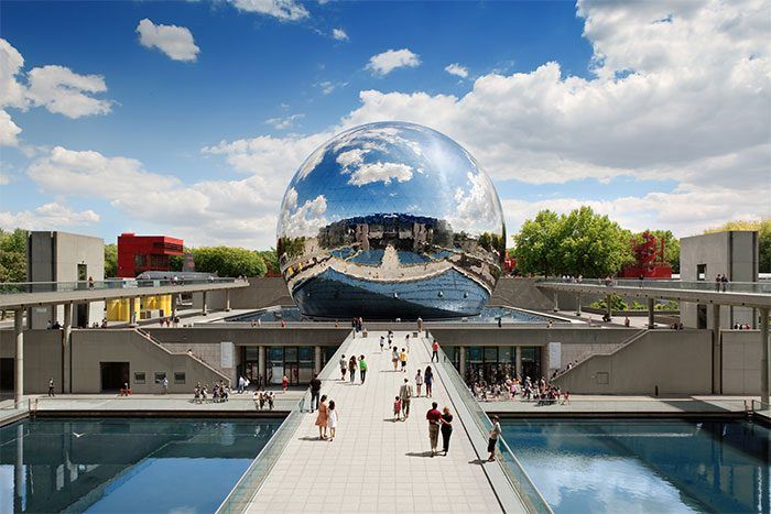 Reflective chrome sphere structure with walkway and visitors at La Villette science museum in Paris.