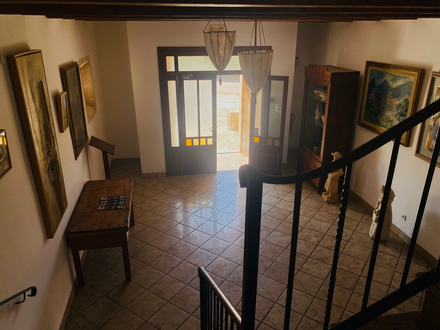 Interior corridor with terracotta tiled floors and dark wooden beams featuring traditional rustic architecture.