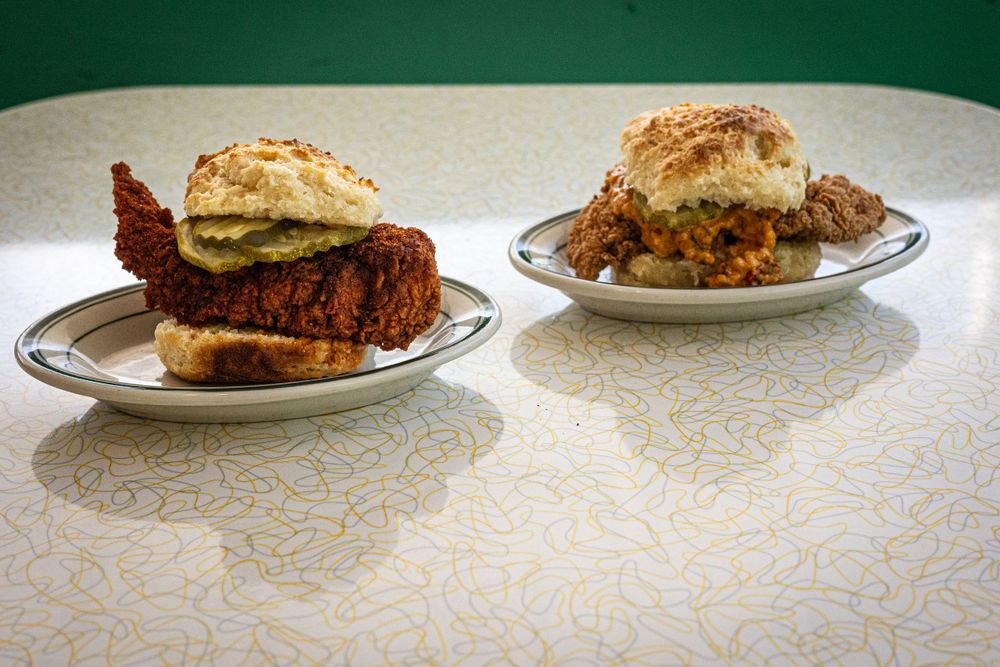 Two plated dishes served on classic diner plates with white patterned tablecloth.